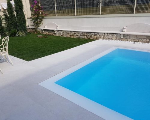 Bordo piscina in marmo con muretto in pietra
